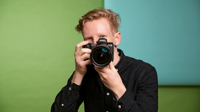 Luontokuvaaja Konsta Punkka poseeraa kameran kanssa